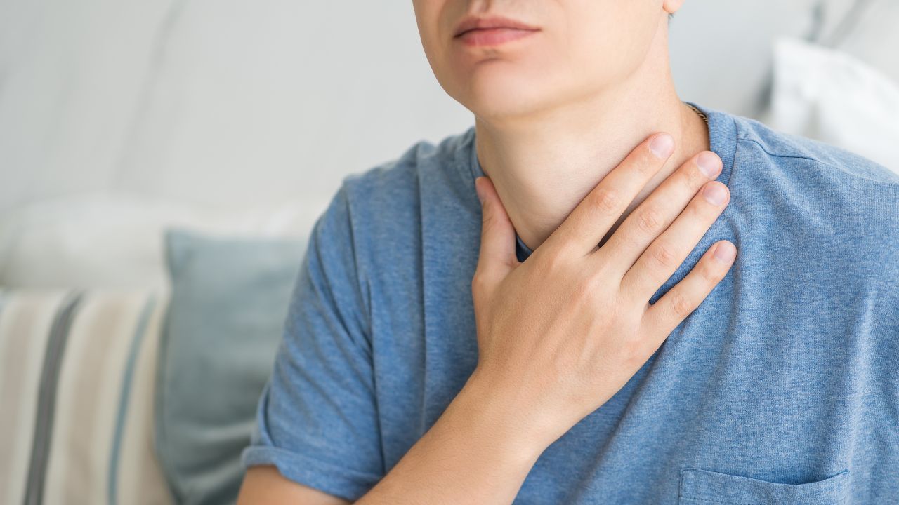 A person holding his throat