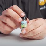 MIST's featured image for What are nic salts post, showing a person holding a nic salt bottle.