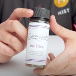 A person holding a high VG vape juice shortfill